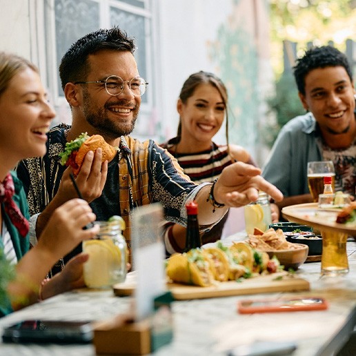 Dental crown patient enjoying food with friends