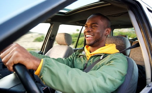 Man smiles while driving