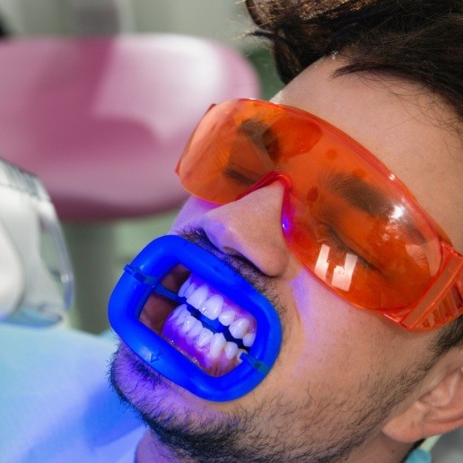 Man receiving professional teeth whitening from his dentist