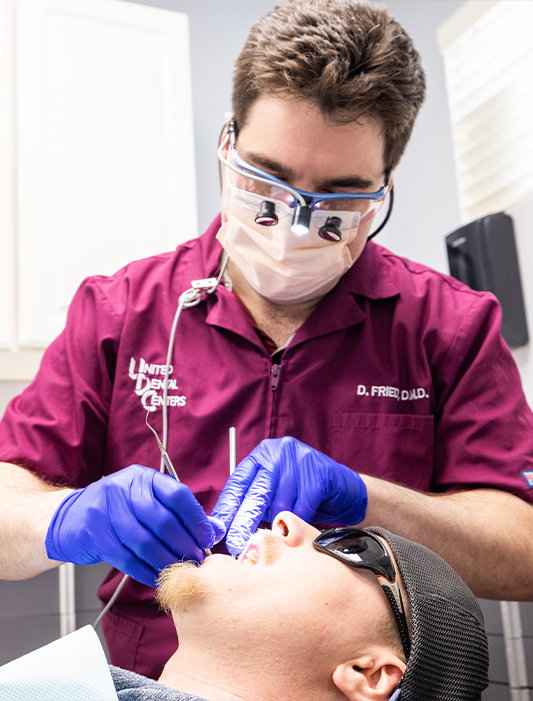 Dentist examining a patient with dental implants in Whiting
