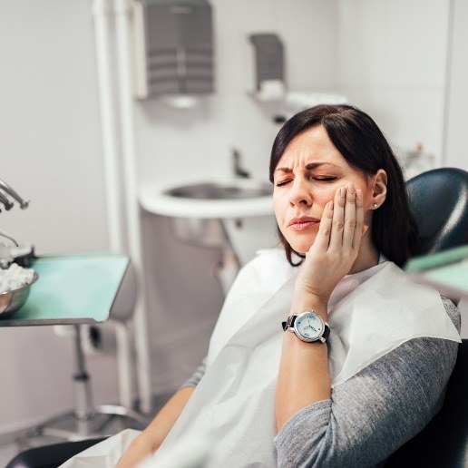 Dental patient holding the side of her face in pain