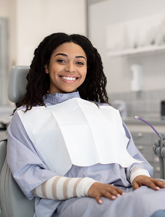 Woman smiling while sitting in treatment chair