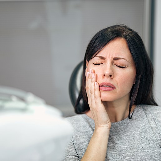 Patient with toothache sitting in treatment chair