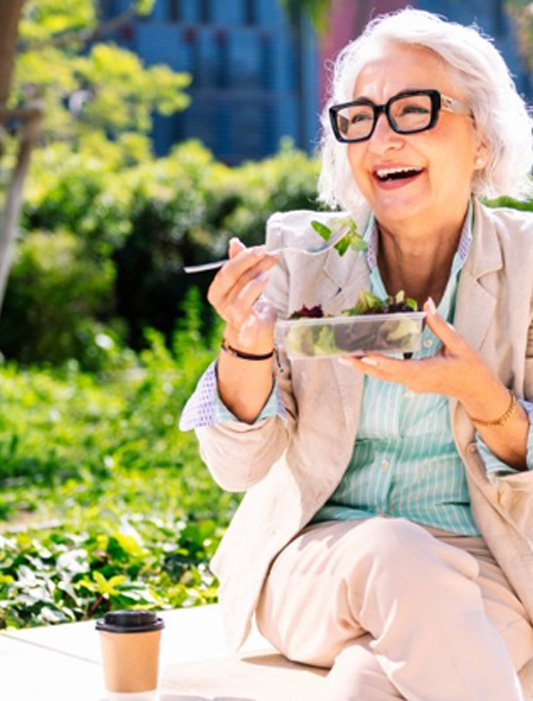 Lady smiles while enjoying salad