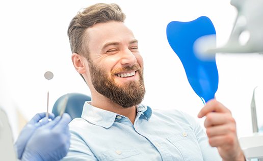 man smiling in dental mirror 