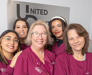 Group of smiling dental team members at United Dental Centers of Whiting