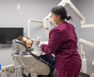 Dental team member examining the mouth of a patient