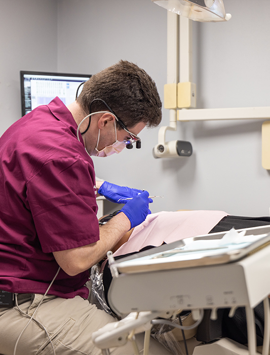 Dentist examining patient before replacing missing teeth in Whiting