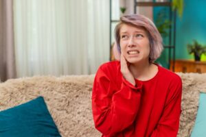 Woman holding jaw in pain.
